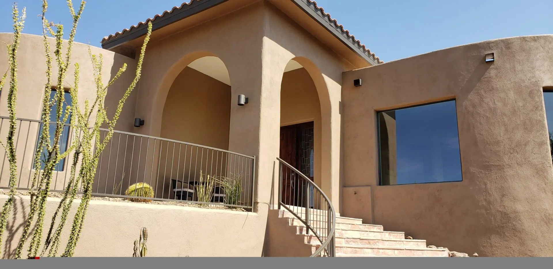 A house with arches and steps leading to the front door.