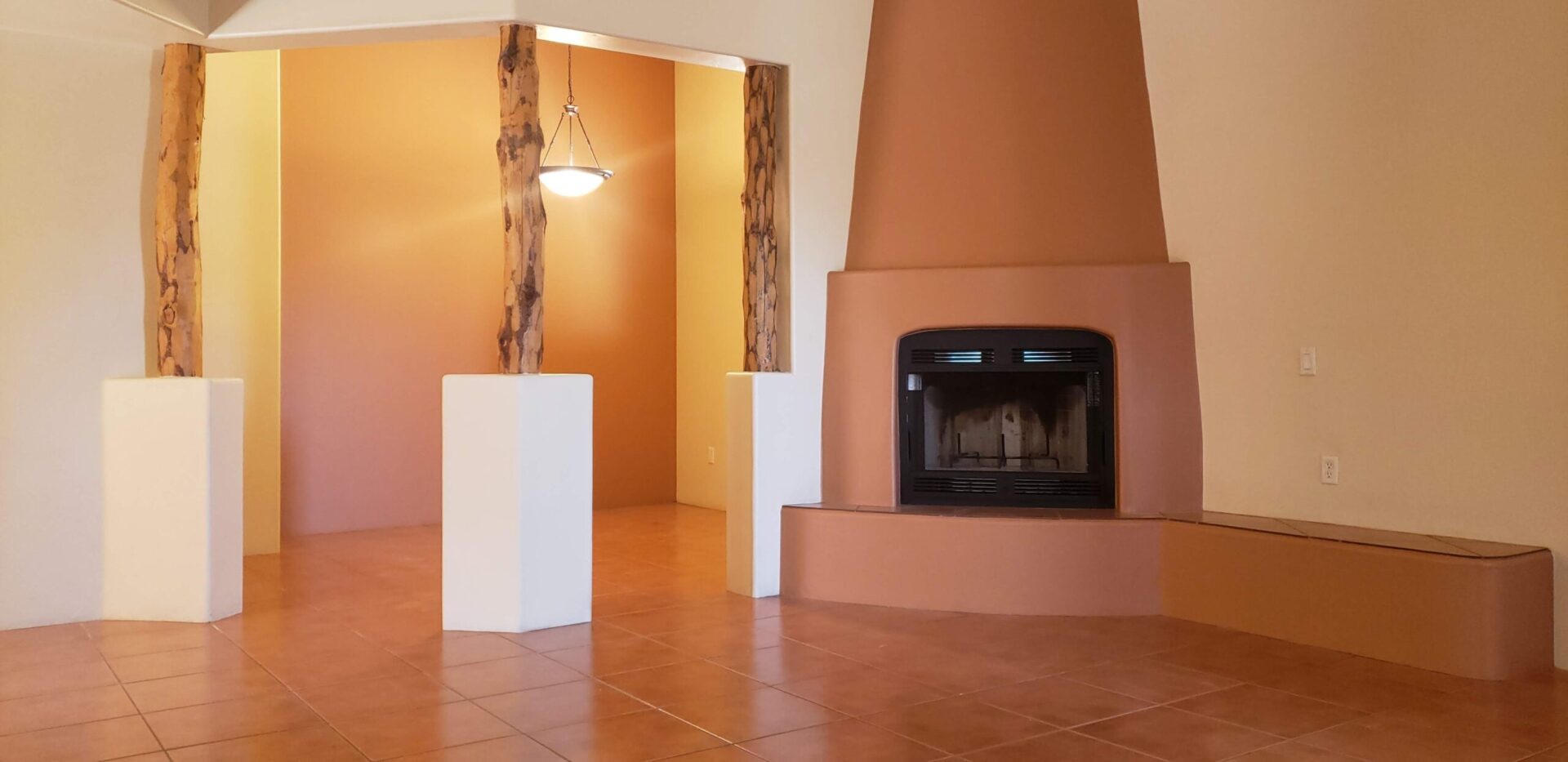 A room with a fireplace and tiled floors