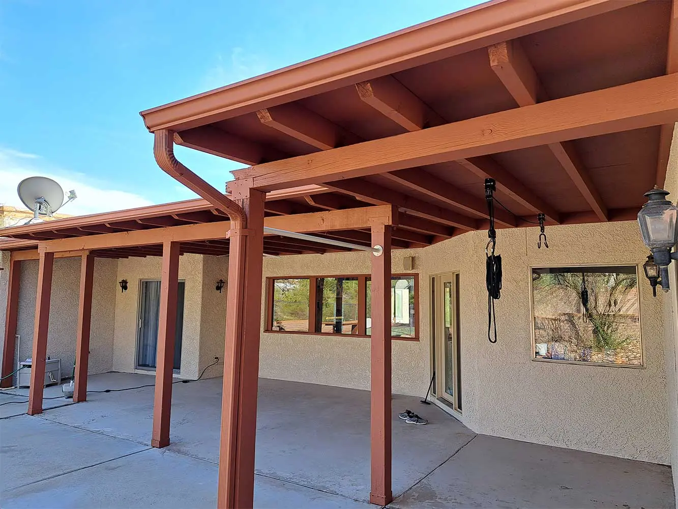 A patio with wooden posts and a roof