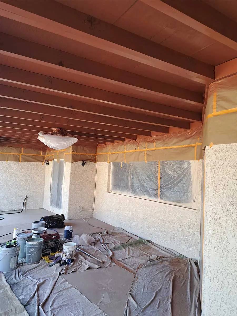 A room with paint and wood beams in it.