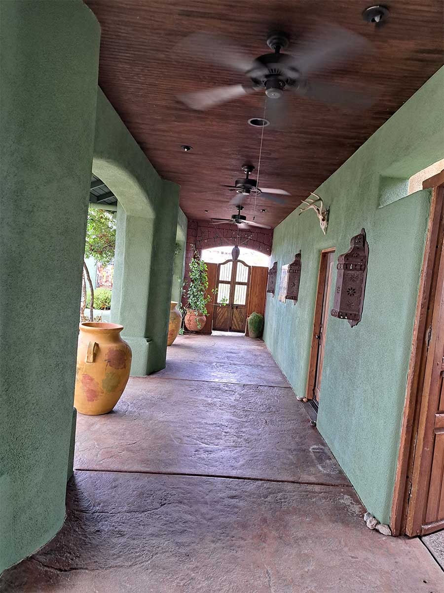 A long hallway with green walls and brown ceiling.