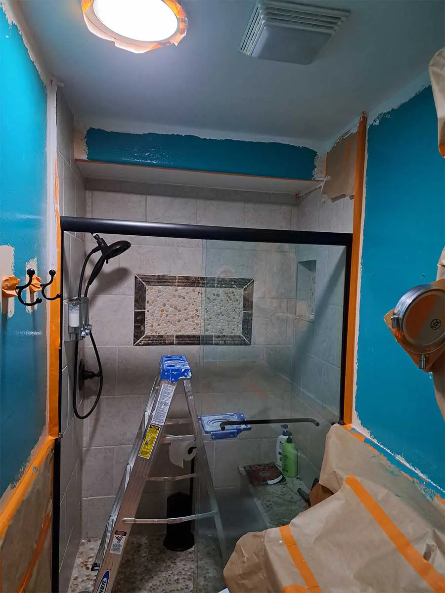 A bathroom with blue walls and a mirror.