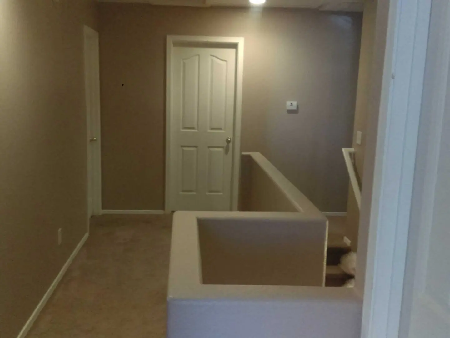 A room with a door open and a white couch.